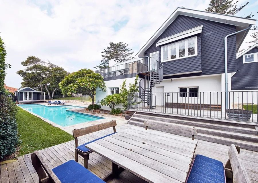 Modern House with A Turquoise Pool and Lounge Chairs in A Sunny Backyard — Fineworx Joinery in Warnervale, NSW
