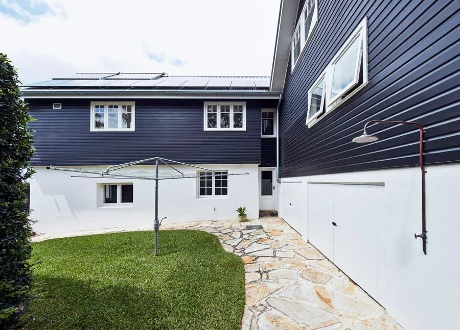 Backyard with Stone Path and Dark Blue House with White Lower Walls — Fineworx Joinery in Warnervale, NSW