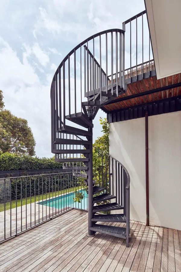 Black Spiral Staircase on A Wooden Deck Beside a Pool and White Building — Fineworx Joinery in Warnervale, NSW