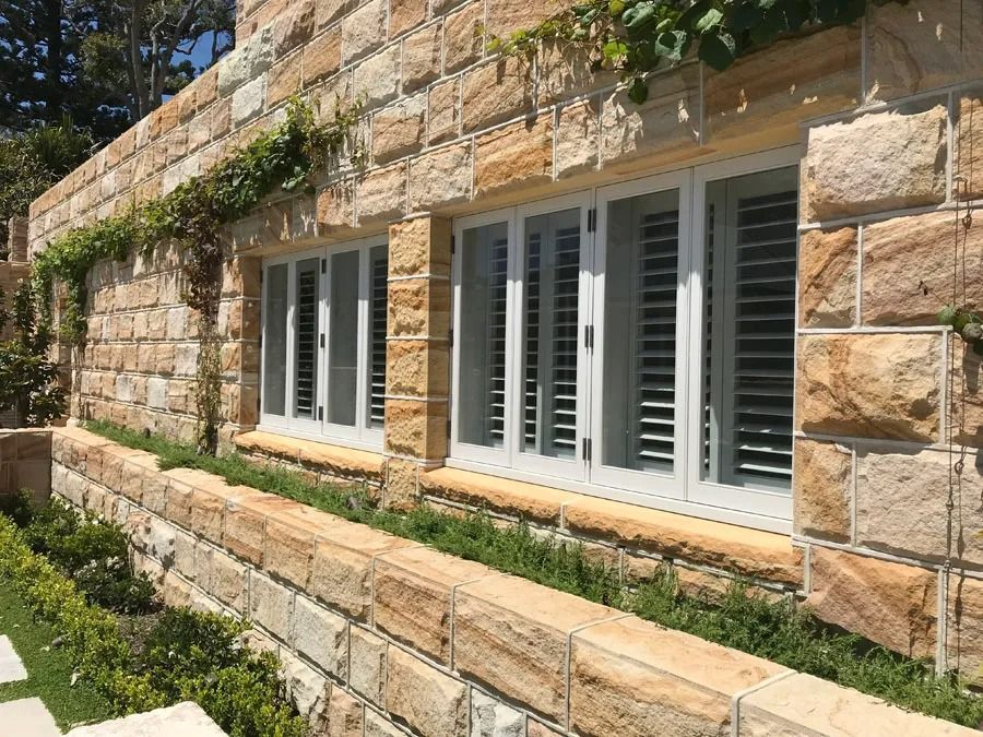 Stone House Exterior with White Shuttered Windows — Fineworx Joinery in Warnervale, NSW
