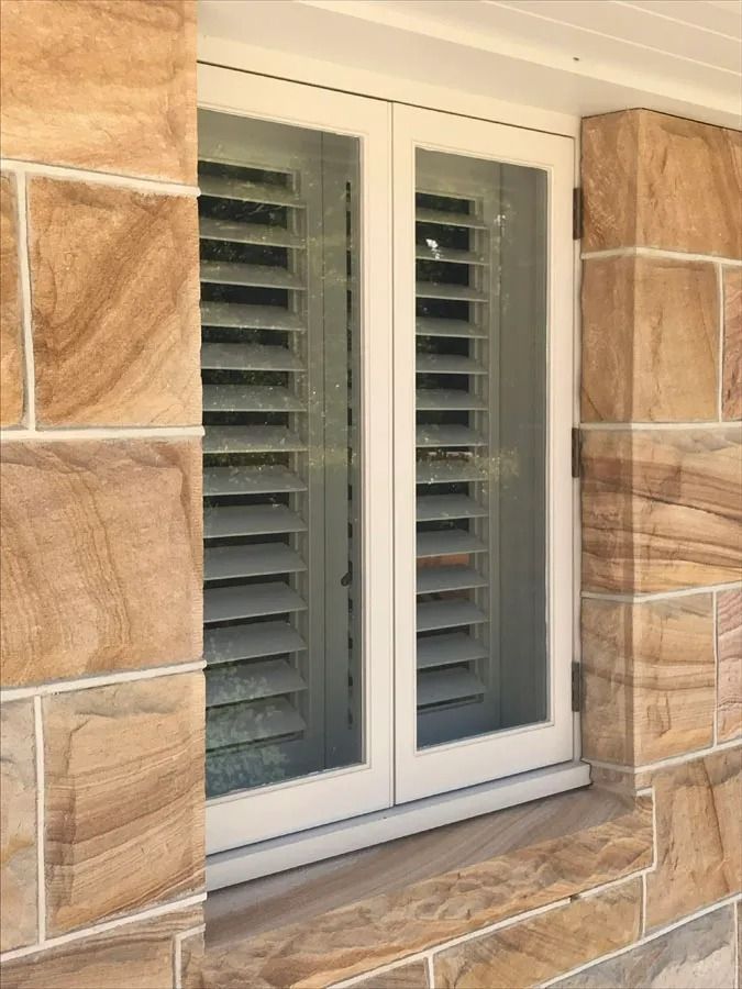 White Window Shutters Set in A Tan Stone Wall — Fineworx Joinery in Warnervale, NSW