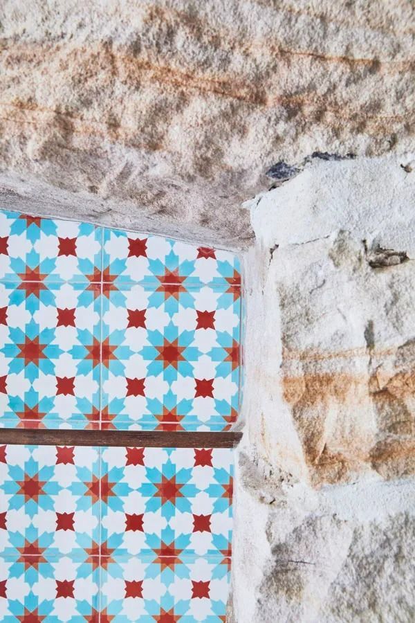 Blue and Red Geometric Tile Pattern Beside a Rough White Stone Wall — Fineworx Joinery in Warnervale, NSW