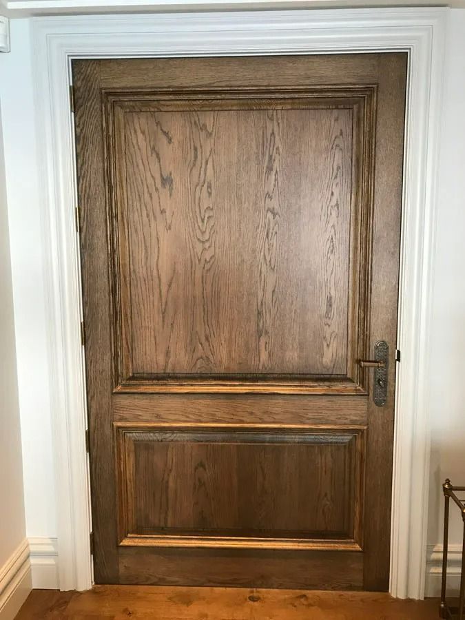 Dark Wooden Interior Door with Paneling and White Trim in A Home Hallway — Fineworx Joinery in Warnervale, NSW