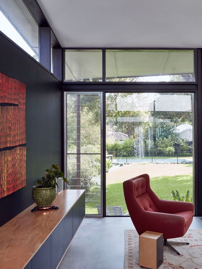Modern Living Room with A Red Chair and Large Windows Overlooking a Garden — Fineworx Joinery in Warnervale, NSW