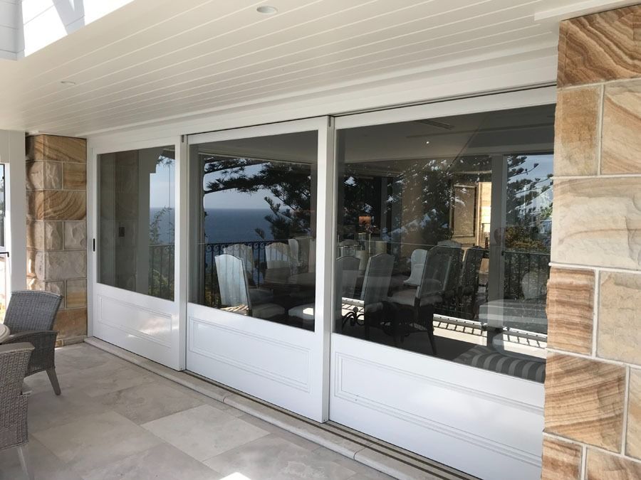 Patio with Large Sliding Glass Doors Reflecting Outdoor Seating — Fineworx Joinery in Warnervale, NSW