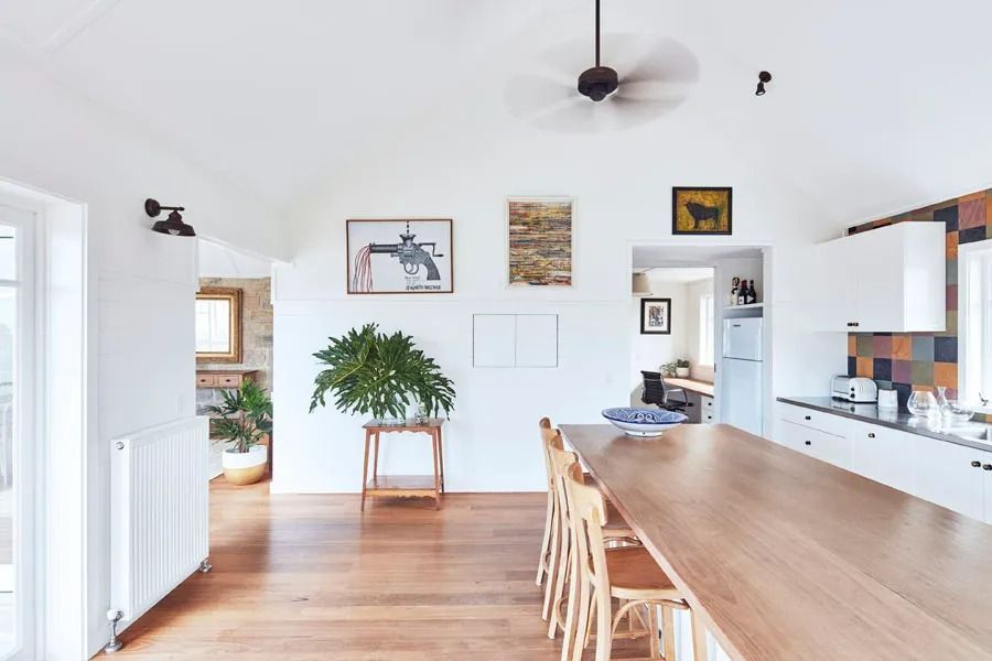 Modern Kitchen and Dining Area with Wooden Table and A Potted Plant by The Window — Fineworx Joinery in Warnervale, NSW