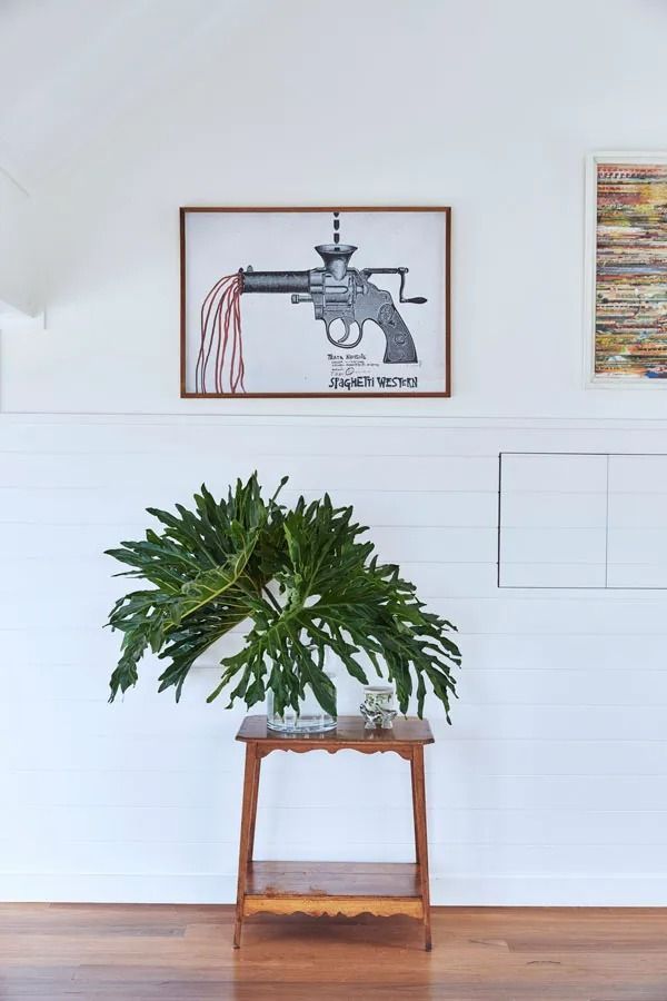 Potted Green Plant on A Wooden Table Beneath Framed Wall Art in A Bright Room — Fineworx Joinery in Warnervale, NSW