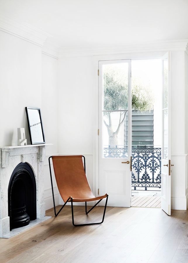 Minimal White Room with A Brown Lounge Chair and Open Balcony Doors — Fineworx Joinery in Warnervale, NSW