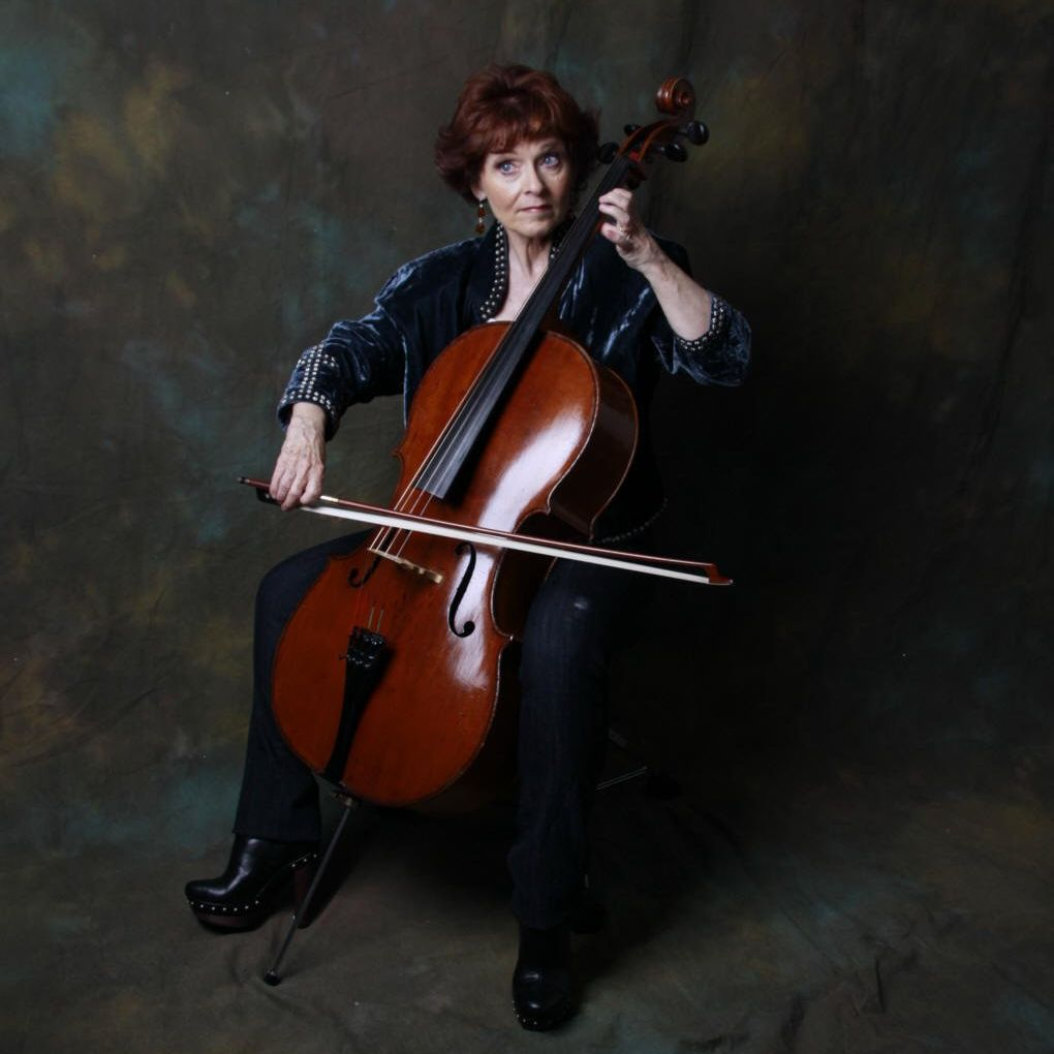 A woman is sitting on a chair playing a cello