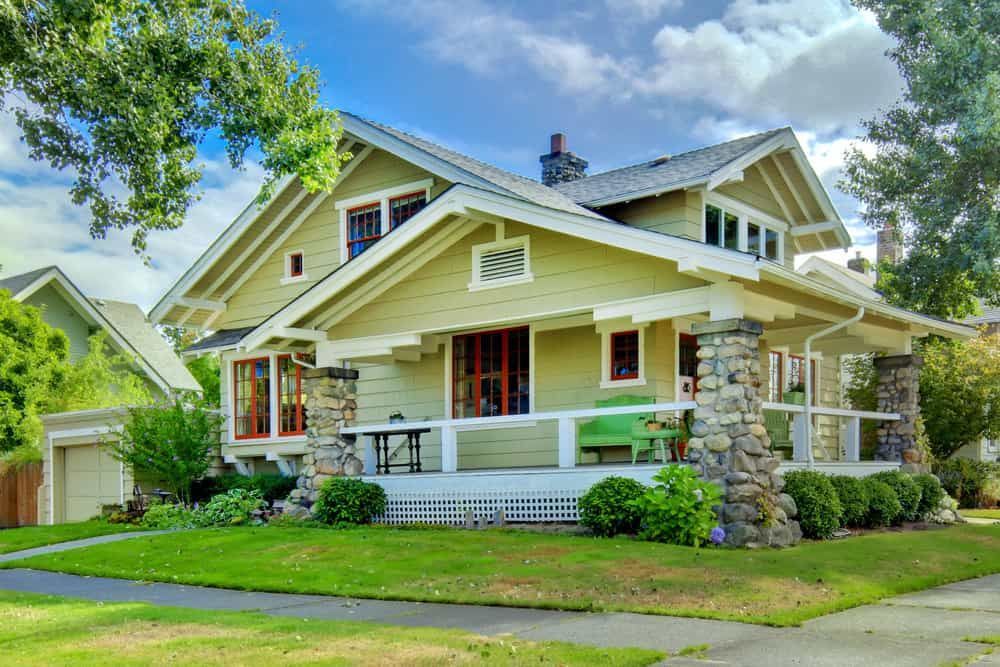 A large yellow house with stone pillars.