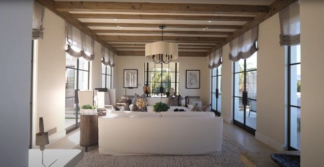 A sitting area with couches, chairs, and lots of windows.