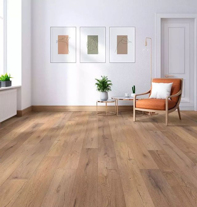 A living room with hardwood floors , a chair and a table.