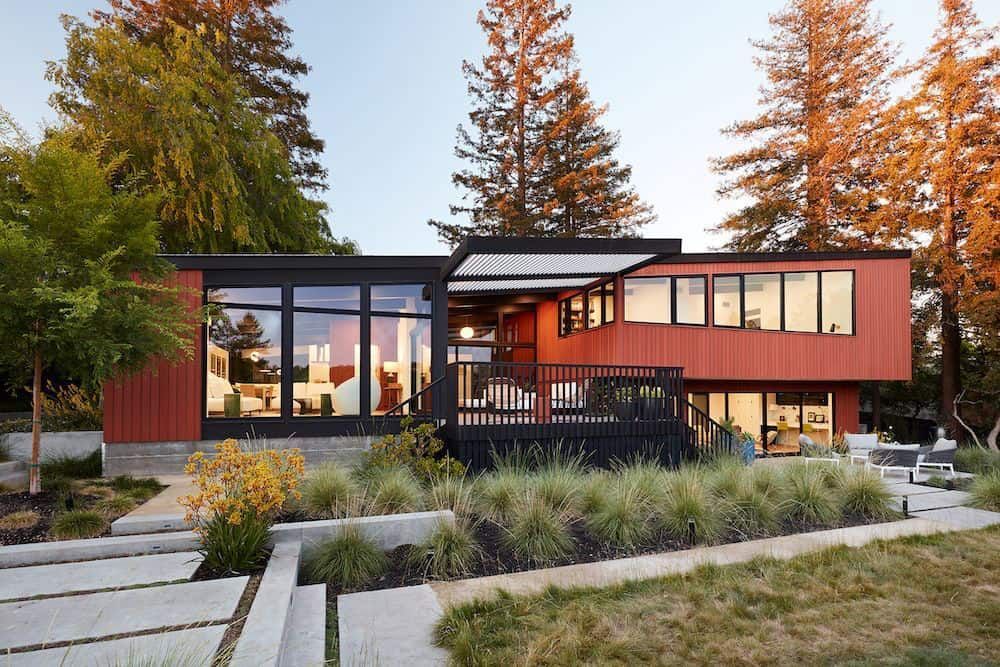 A large red house with a lot of windows is surrounded by trees.