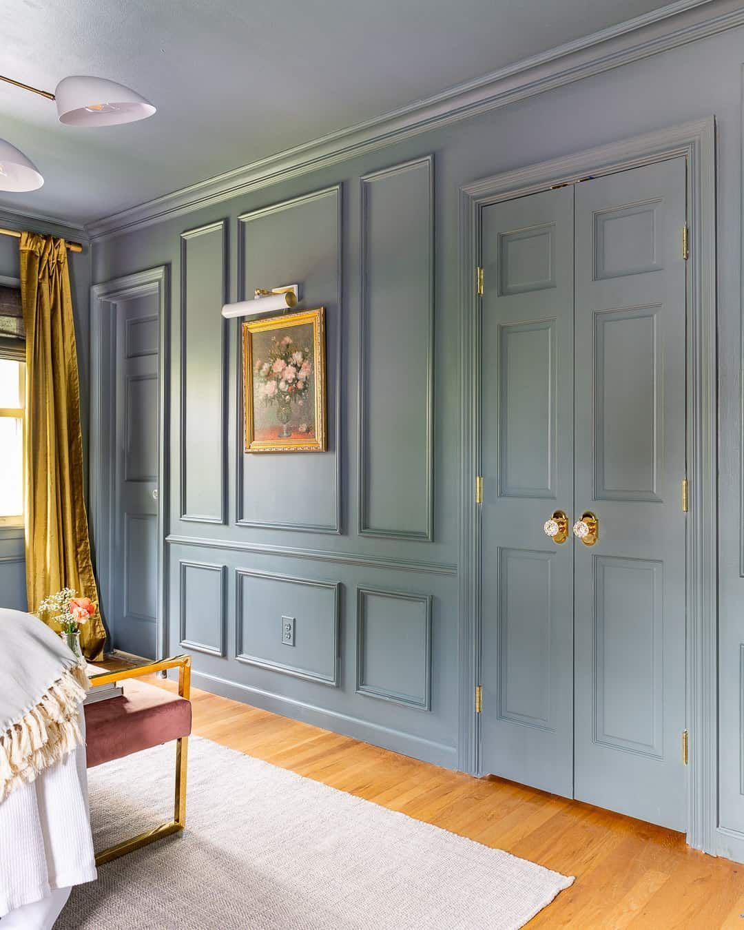A bedroom with a bed , a bench , and a painting on the wall.