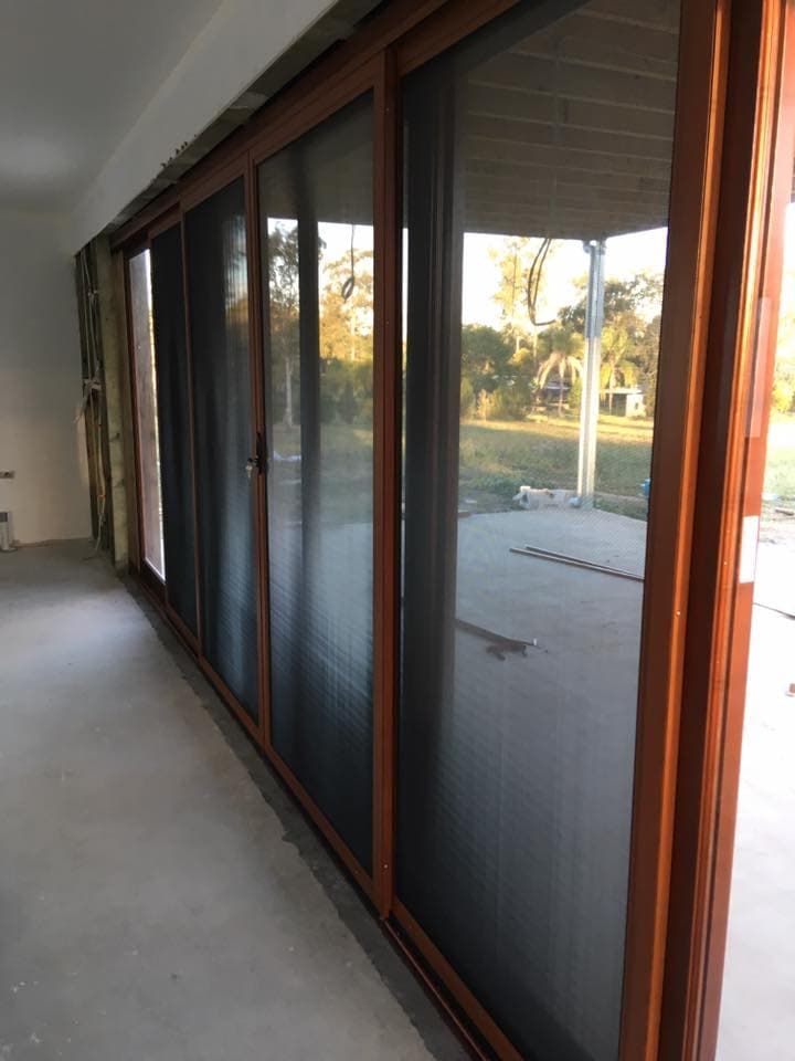 A Long Hallway With Sliding Glass Doors Leading To A Patio — Screen Factory In Byron Bay, NSW