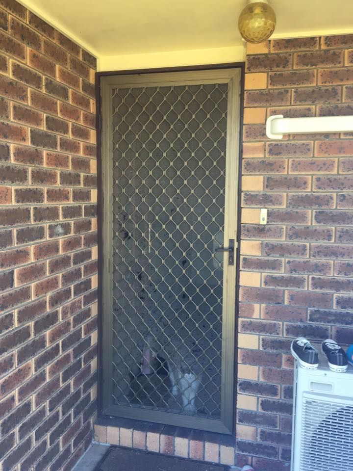 A Brick Wall With A Screen Door And An Air Conditioner — Screen Factory In Ocean Shores, NSW
