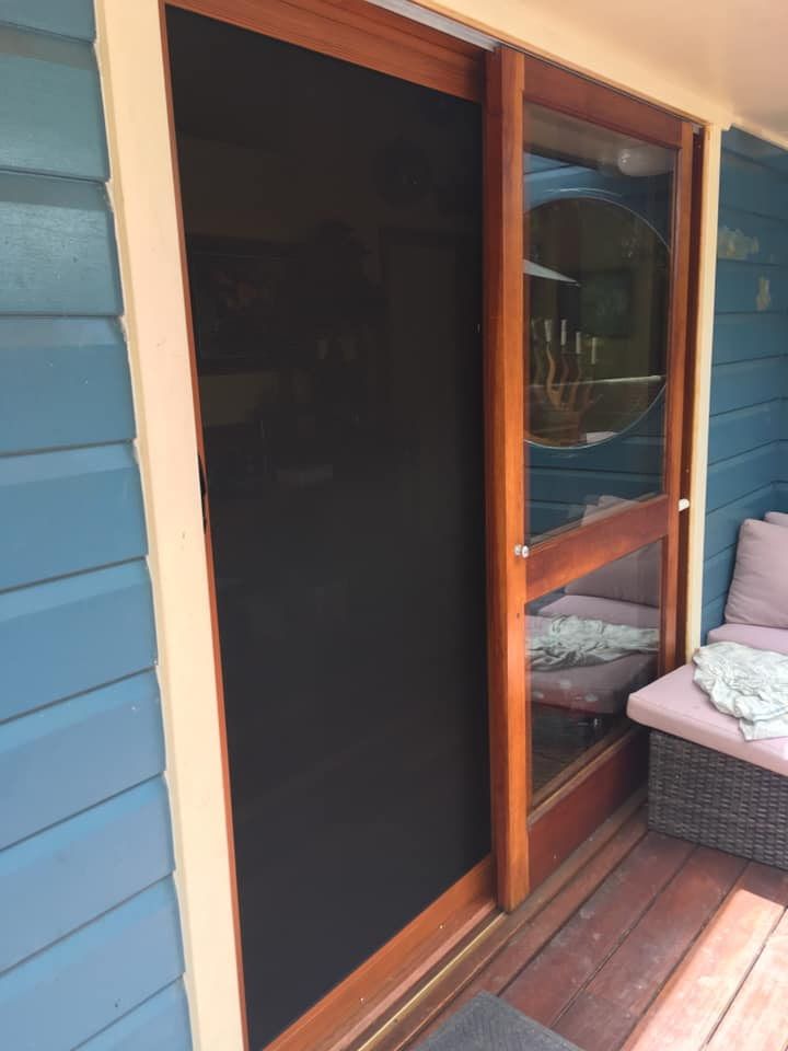 A Sliding Screen Door Is Sitting On A Wooden Deck — Screen Factory In Ocean Shores, NSW