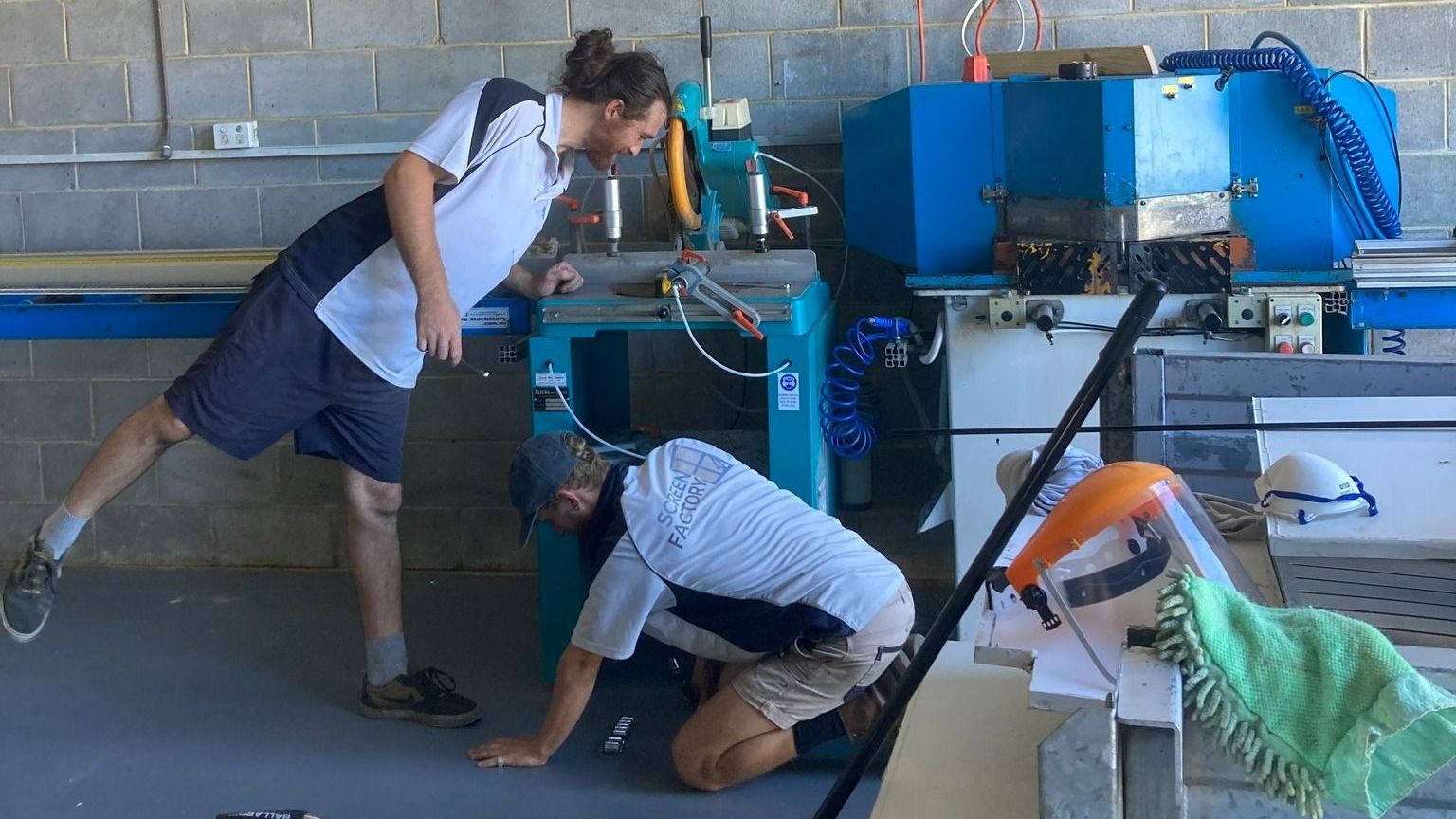 Two Men Are Working On A Machine In A Factory — Screen Factory In Ocean Shores, NSW