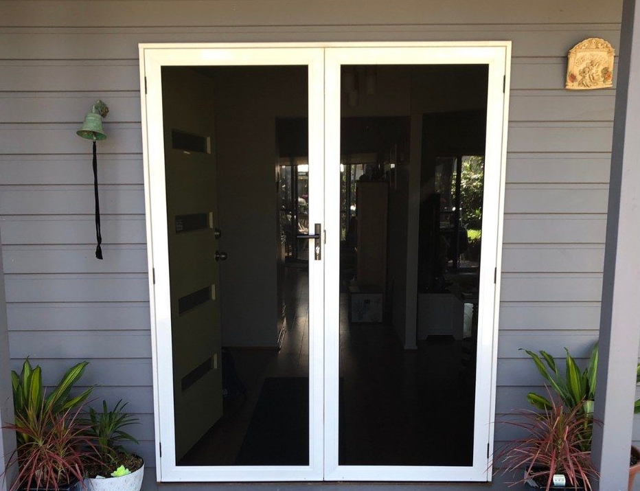 White-framed glass double doors on a gray exterior wall — Screen Factory In Pottsville, NSW