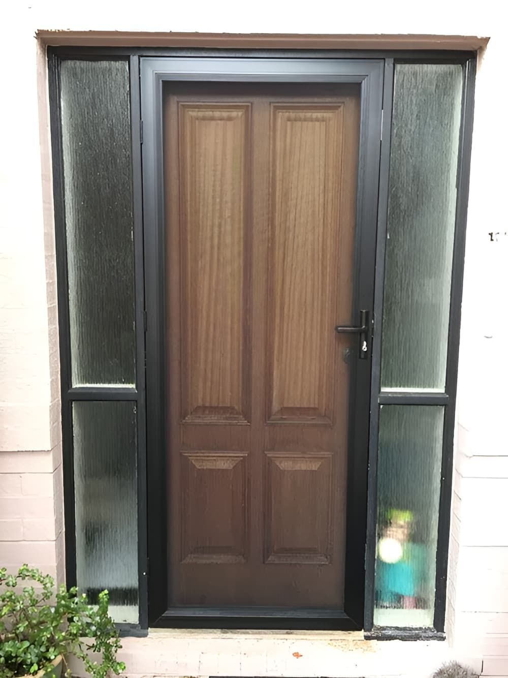 A Wooden Door With A Black Frame Is Sitting On Top Of A White Wall — Screen Factory In Ocean Shores, NSW