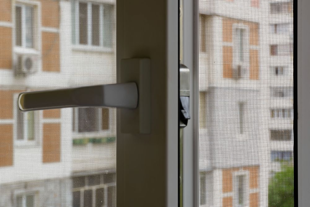 Close-up White Window Handle and Locking Mechanism — Screen Factory In Billinudgel, NSW