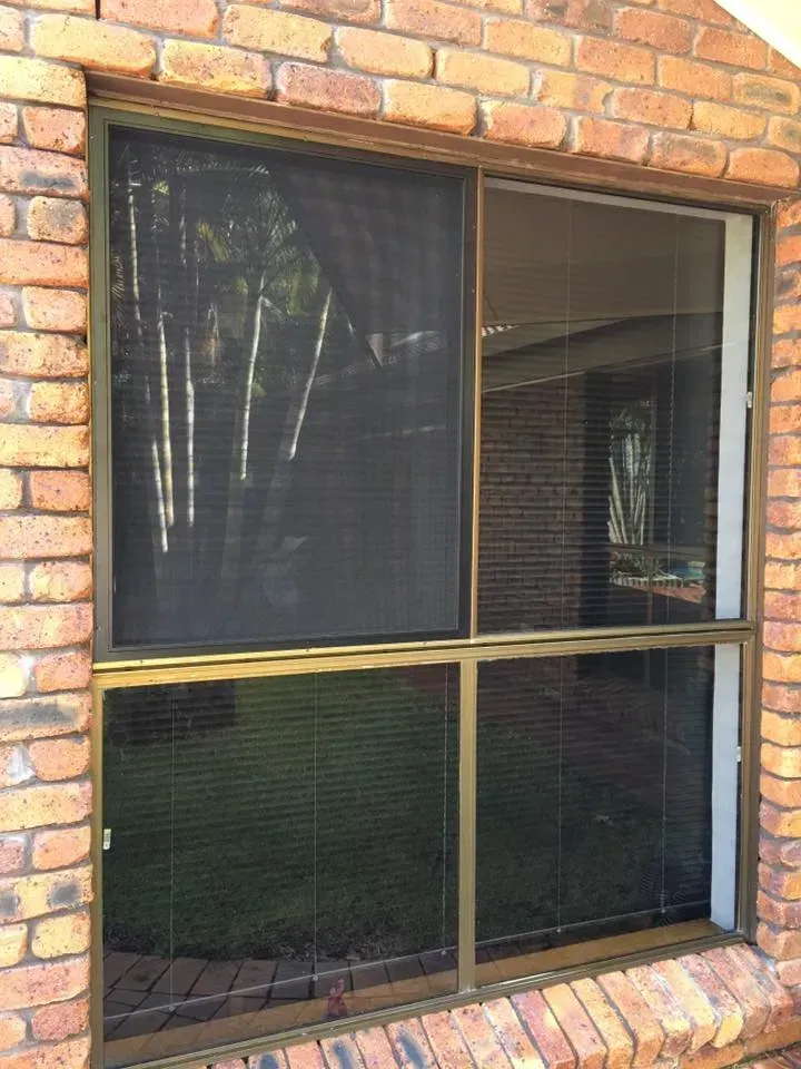A Brick Building With A Window With A Screen On It — Screen Factory In Ocean Shores, NSW