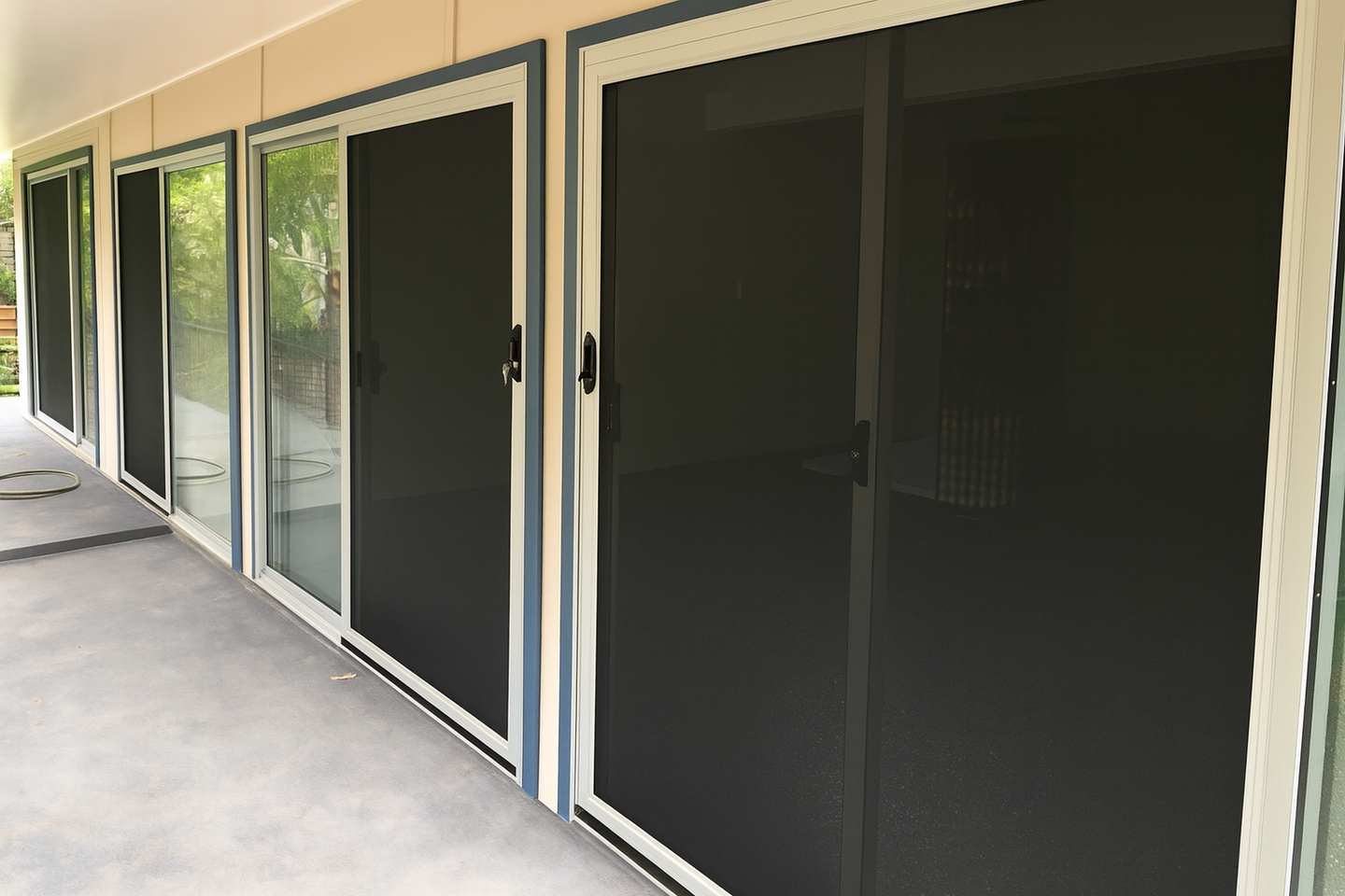 A Row Of Sliding Glass Doors With Black Screens — Screen Factory In Ocean Shores, NSW