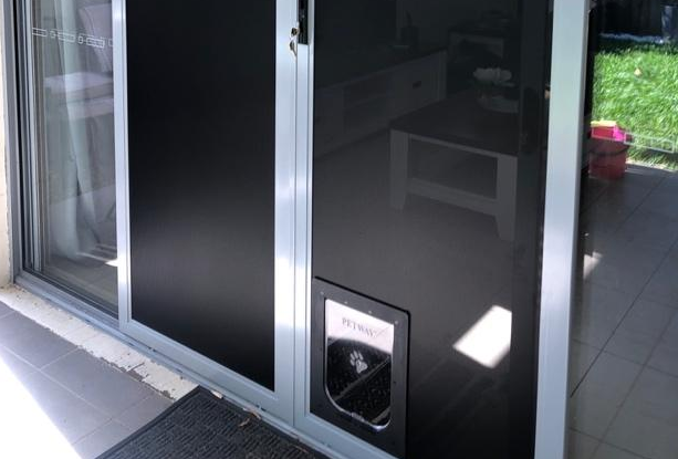 Sliding glass patio door with a small pet door — Screen Factory In Ocean Shores, NSW