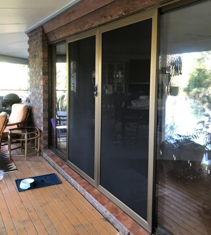A Patio With Sliding Glass Doors And A Rug On The Floor — Screen Factory In Ocean Shores, NSW