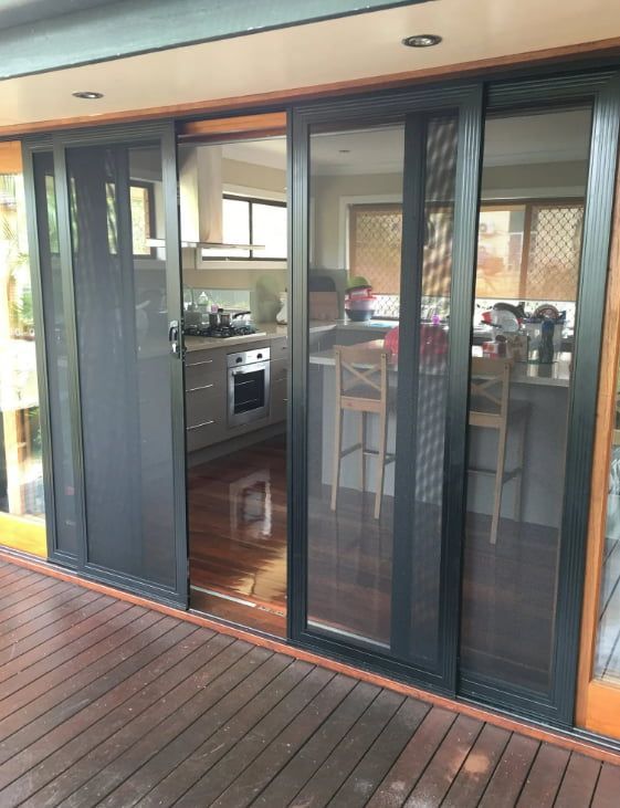 A Kitchen With Sliding Glass Doors And A Wooden Deck — Screen Factory In Ocean Shores, NSW