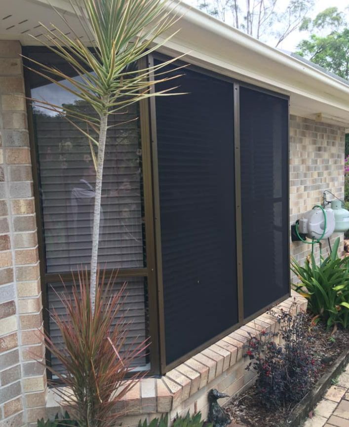 A House With A Screened In Window And A Palm Tree In Front Of It — Screen Factory In Ocean Shores, NSW