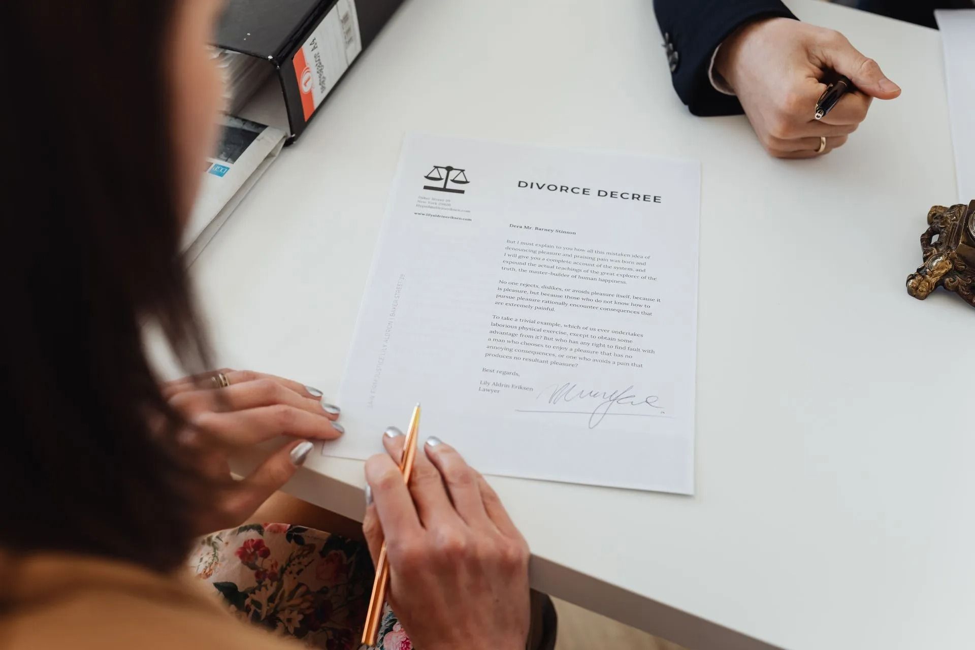 A woman is writing on a piece of paper with a pen.