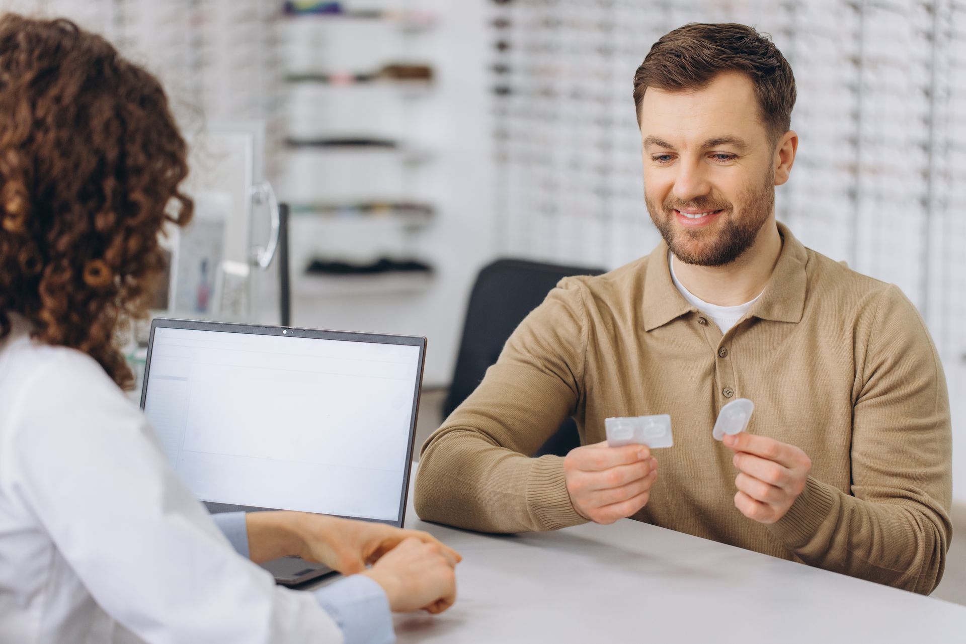 A man is discussing contact lenses with an eye care professional.