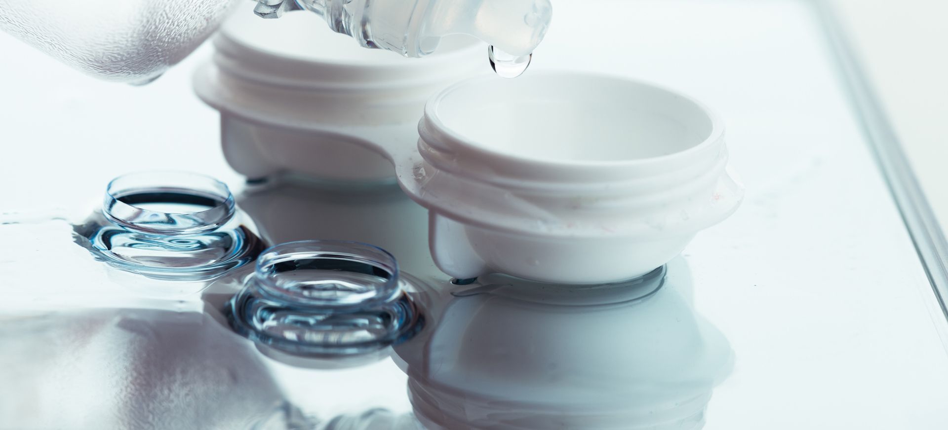 Contact lenses and case being cleaned with solution.