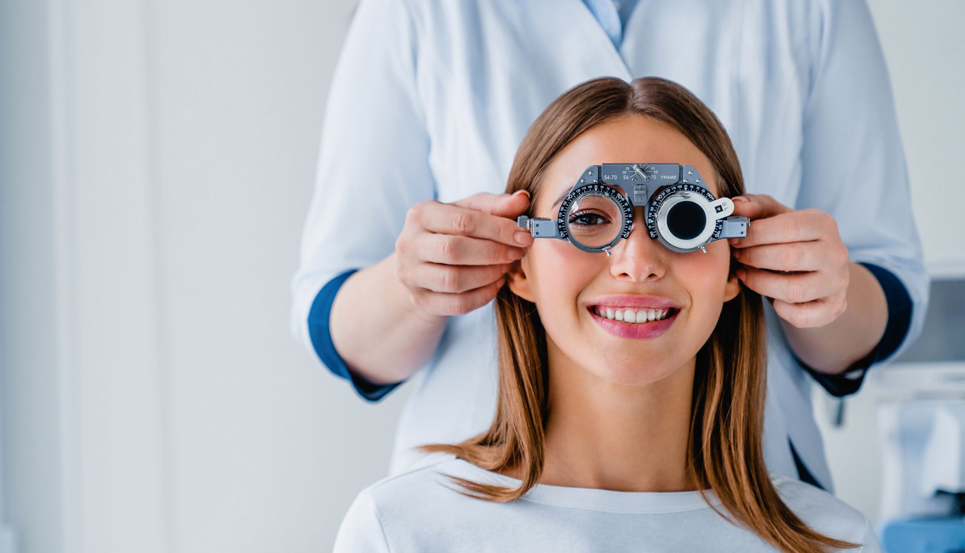 Woman undergoing an eye exam with an optical professional in a clinic setting.