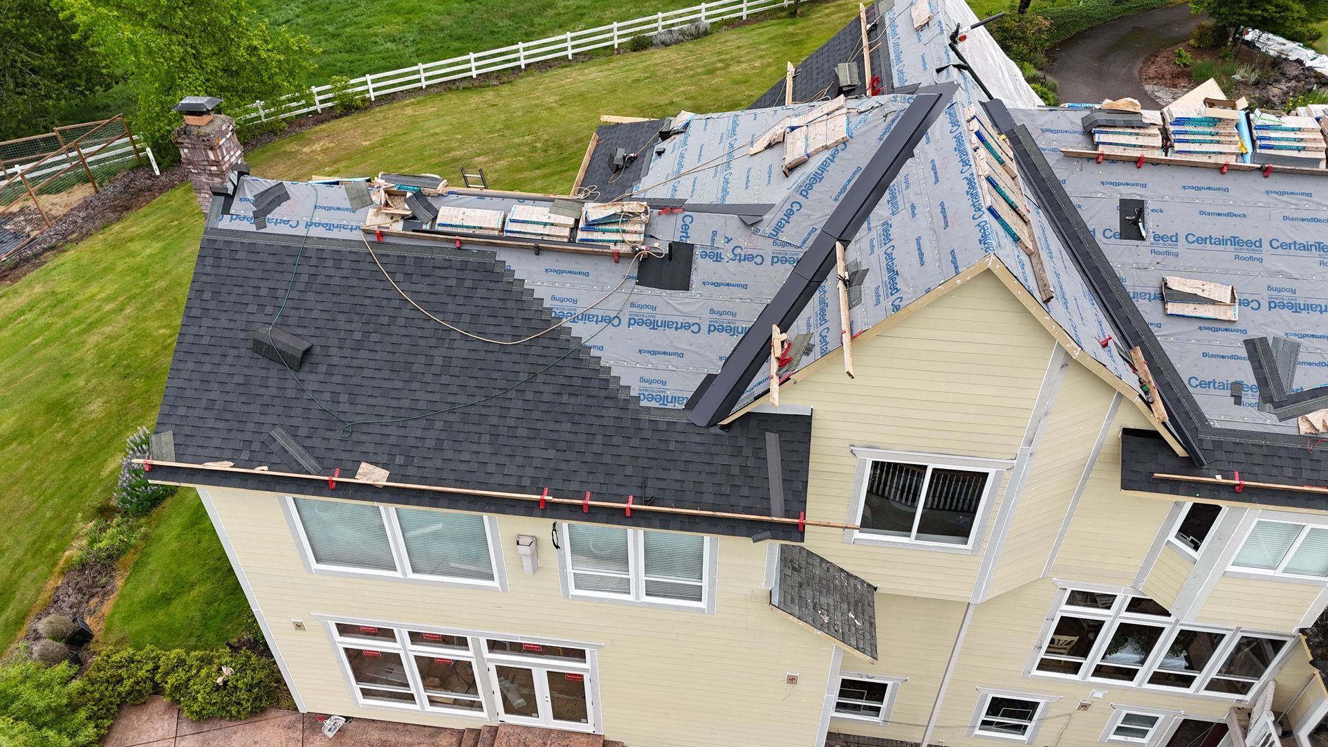 Asphalt shingle roof replacement project showing wear around chimney in Salem, OR