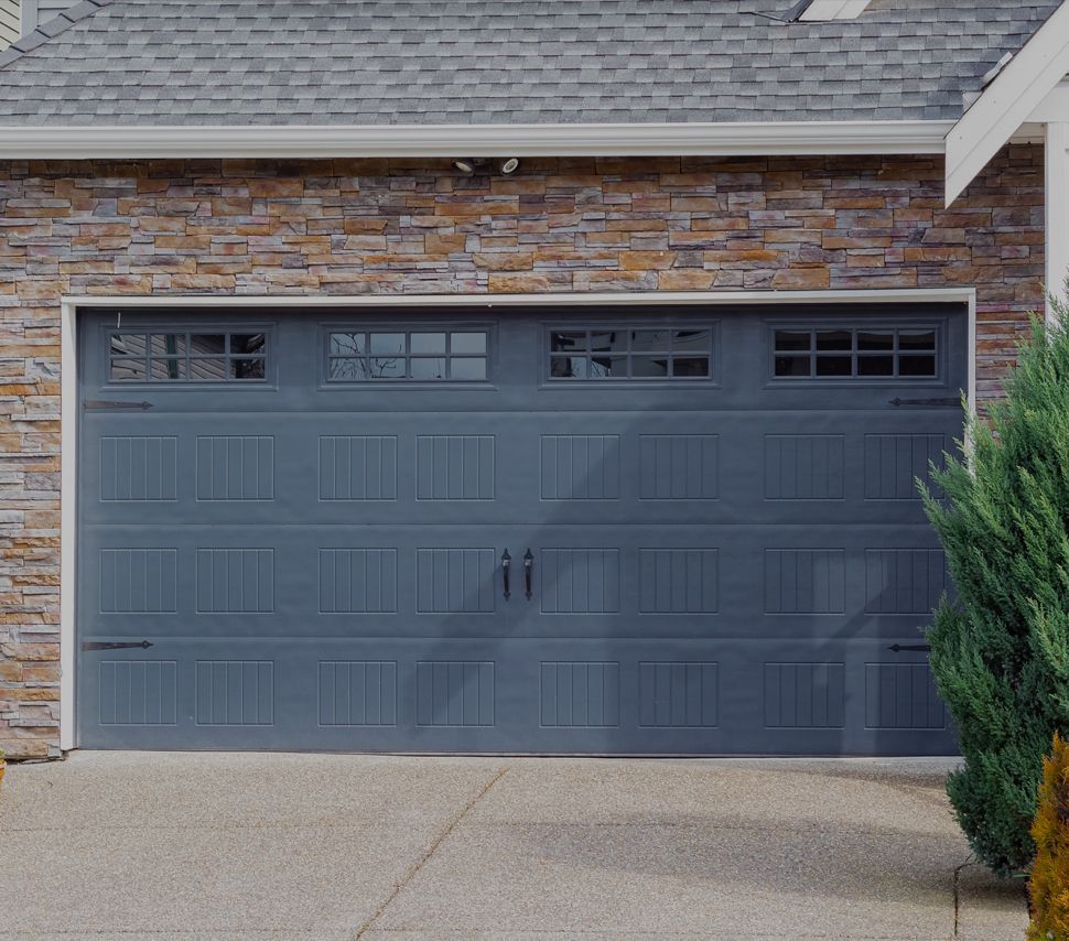 A brick house with a gray garage door