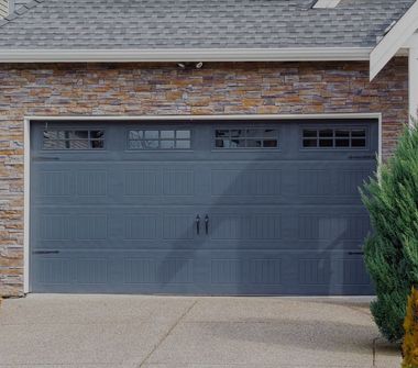 A brick house with a gray garage door