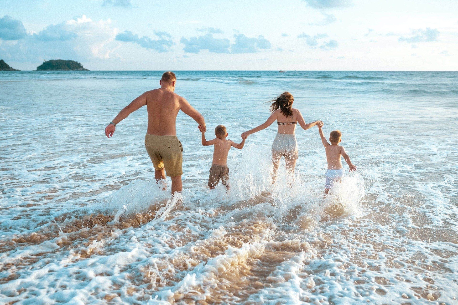 Familie genießt Strandurlaub nach der Einnahme von Familienrabatt