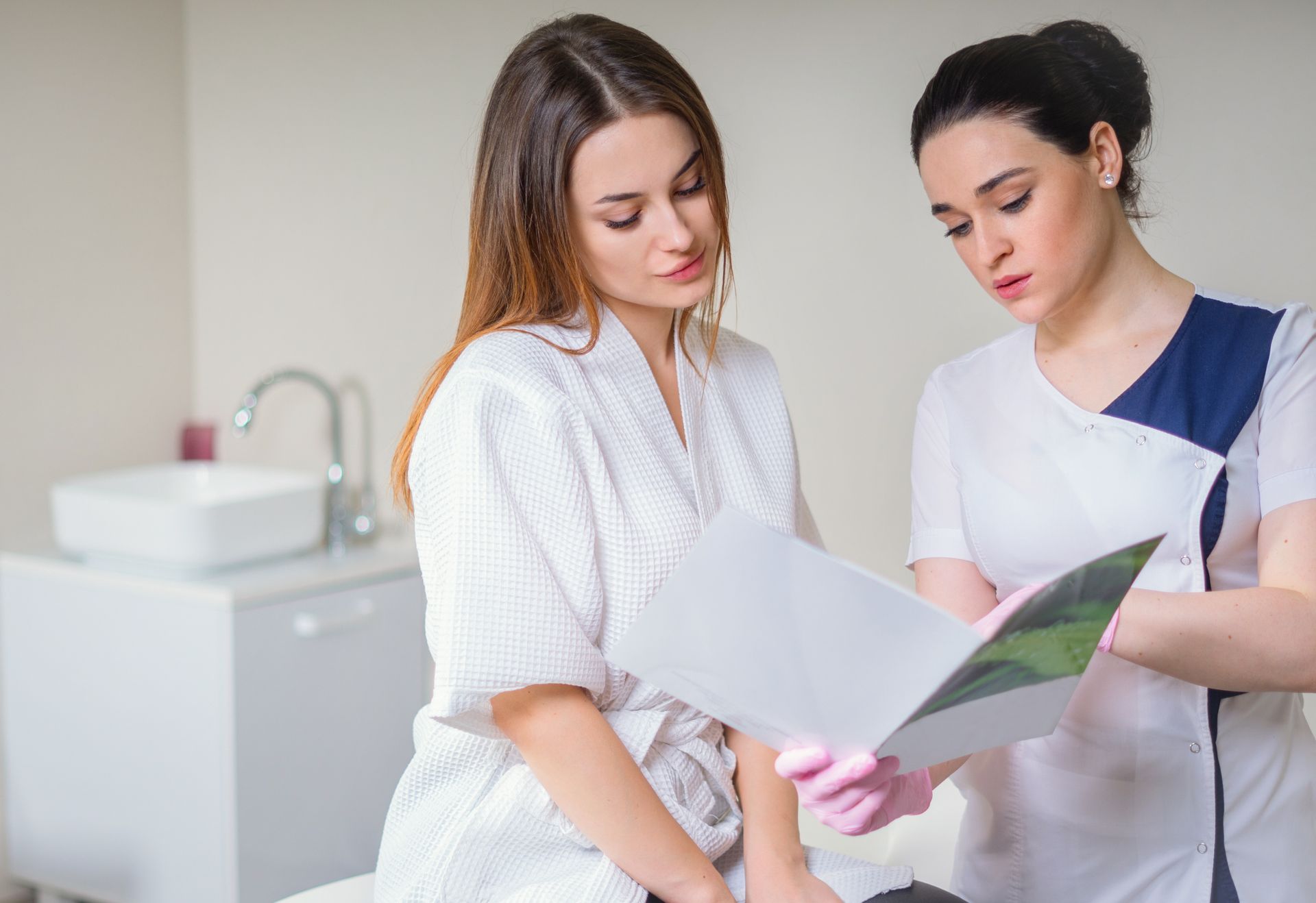 Two medical professionals reviewing papers in a bright clinic room
