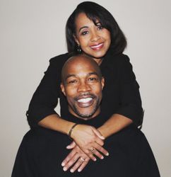 Two friends holding each other while smile into a camera. 