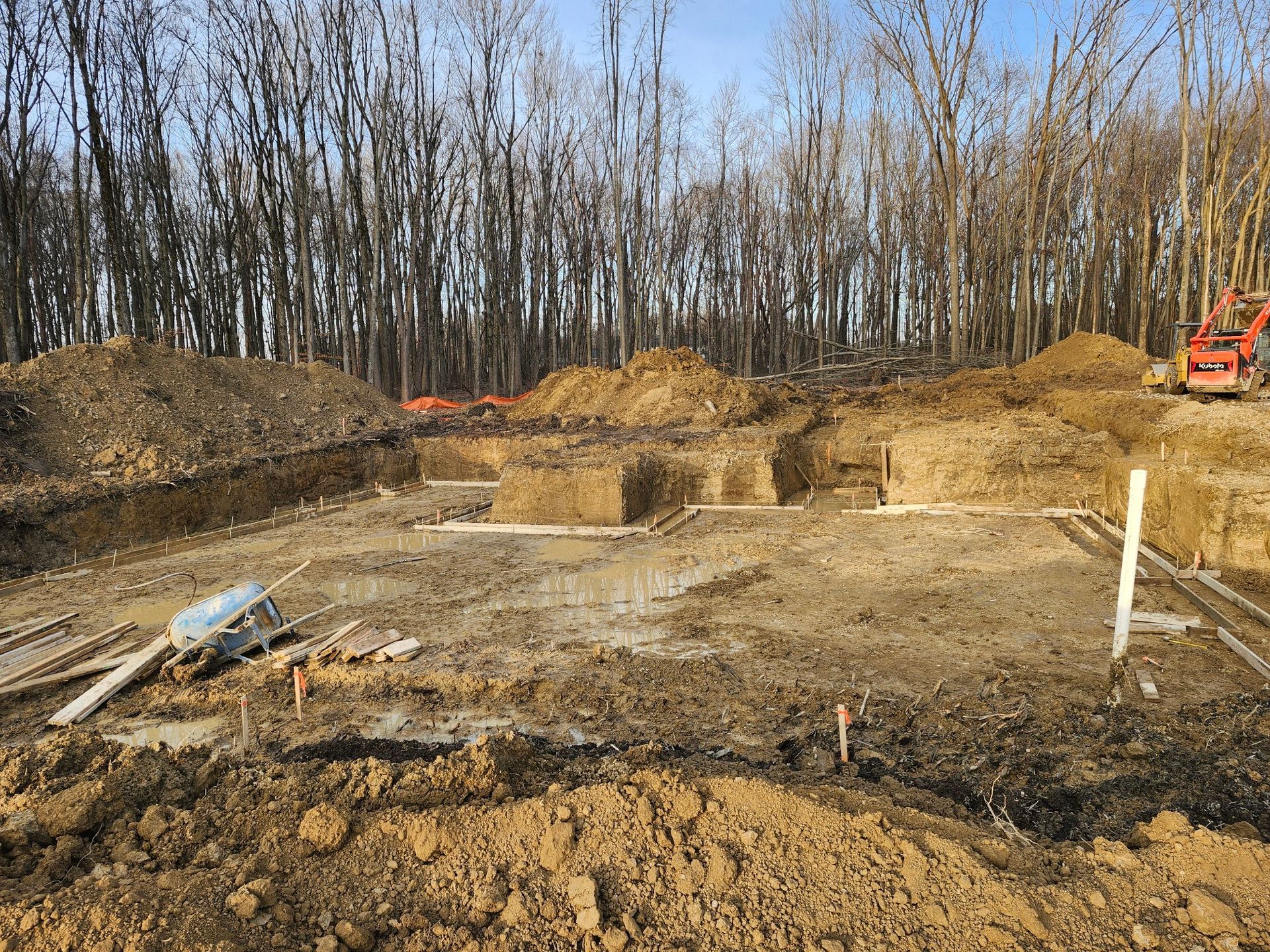 A construction site with a lot of dirt and trees in the background.