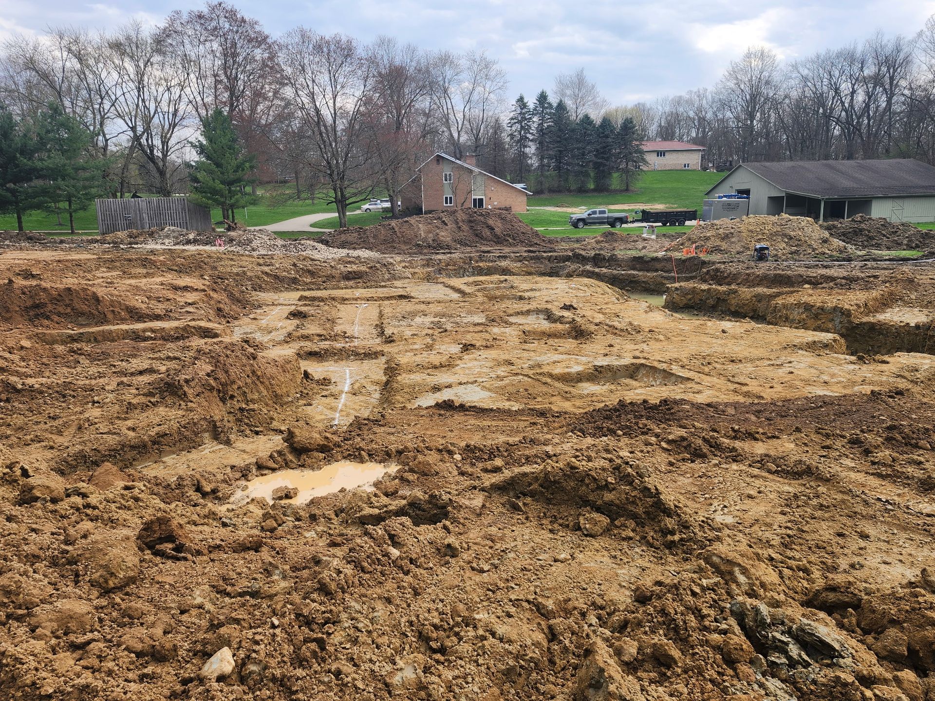 A dirt field with a house in the background
