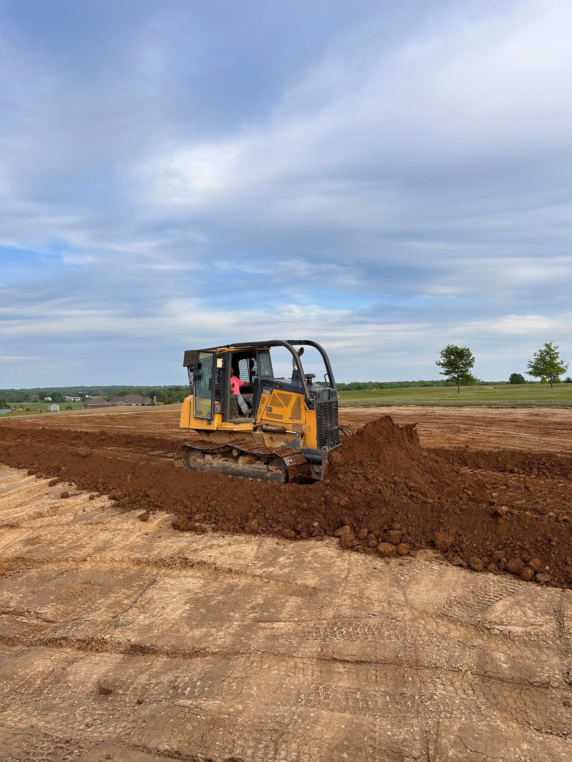 A bulldozer is moving dirt in a field