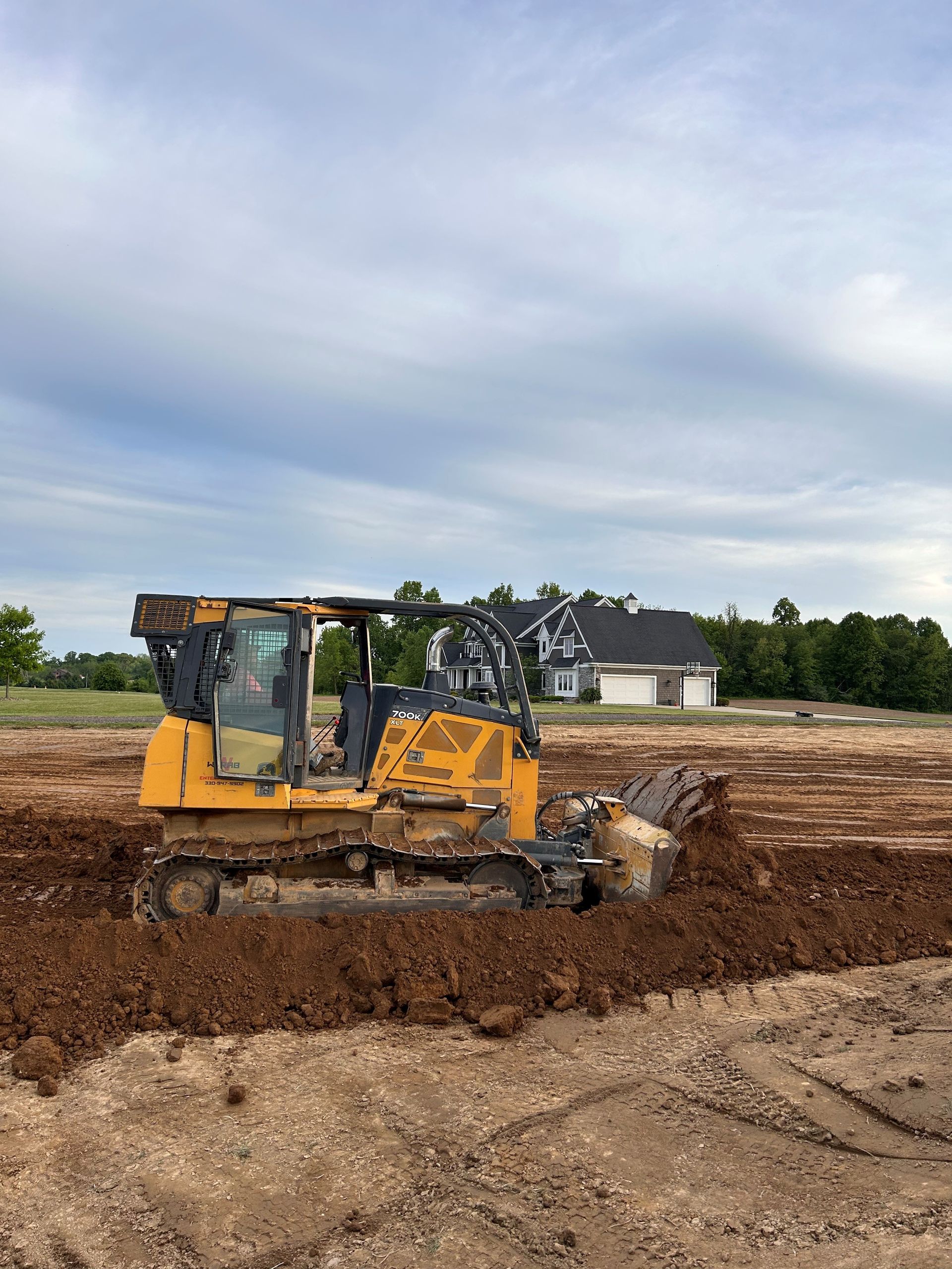 A bulldozer is digging a hole in a dirt field