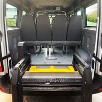 A man in a wheelchair is getting out of a van.