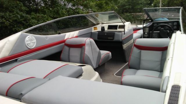 The inside of a boat with grey and red seats