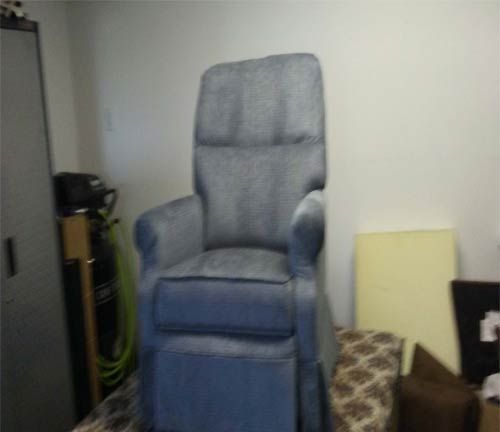 A blue chair is sitting in a room with other furniture.