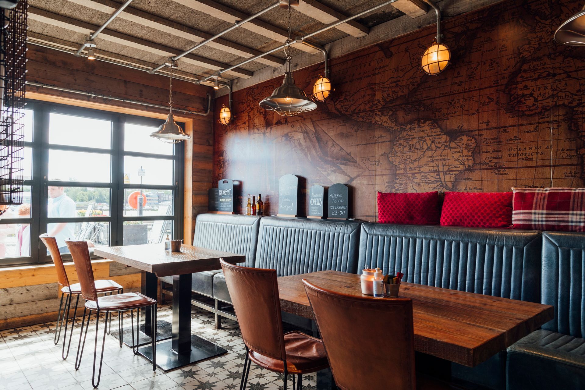 A restaurant with tables and chairs and a map on the wall.