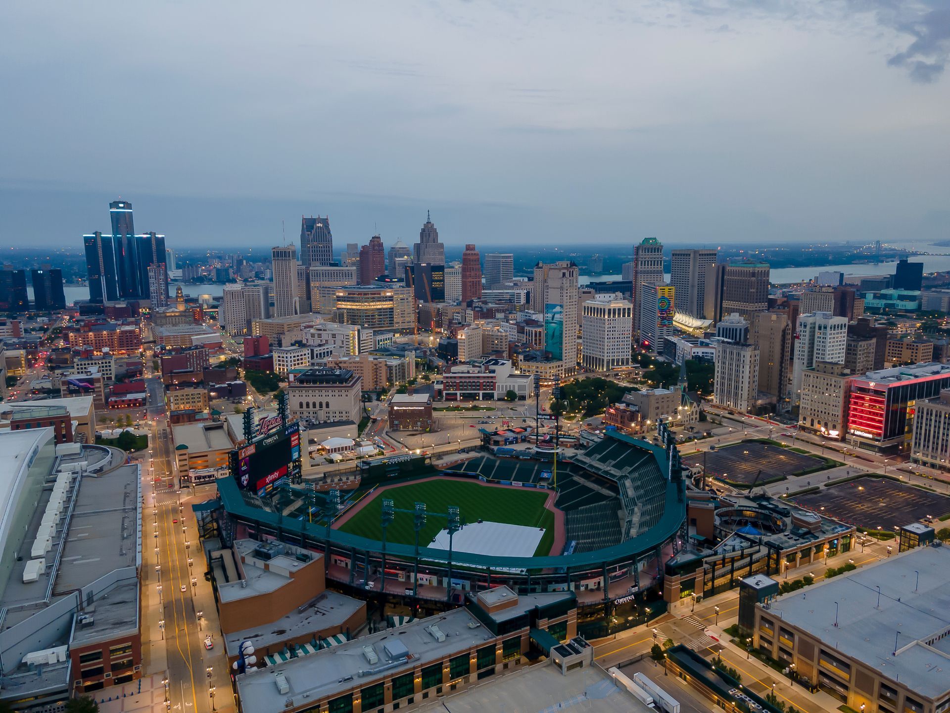 Aerial view of Comerica Park baseball stadium in Detroit, Michigan, at dusk, with the city skyline in the background.